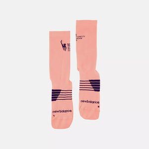 Pair of pink socks with black branding on a white background