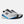 A New Balance running shoe in white, gray, and blue against a light gray background.
