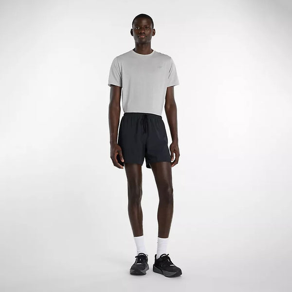 Man wearing a white t-shirt and black shorts on a white background