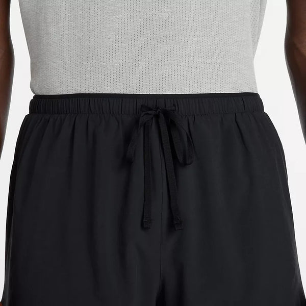 Person wearing black pants with a tie detail on a white background