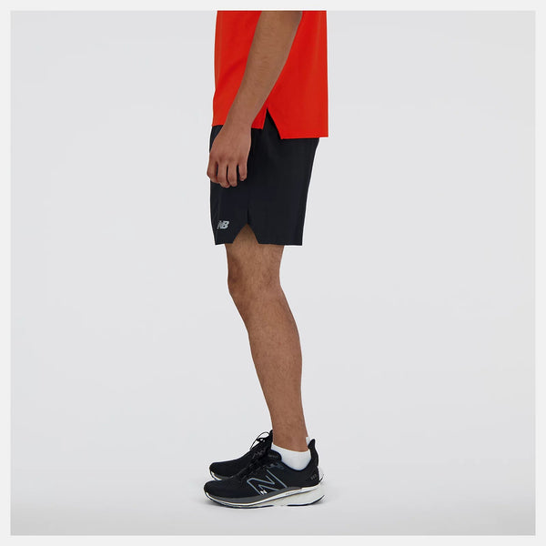 Person wearing black shorts and black sneakers on a white background