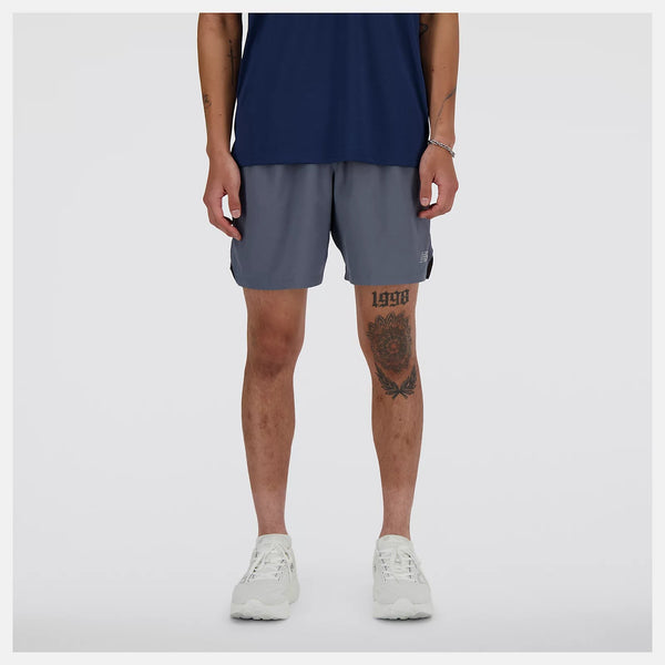 Person wearing navy tank top and gray shorts on a white background