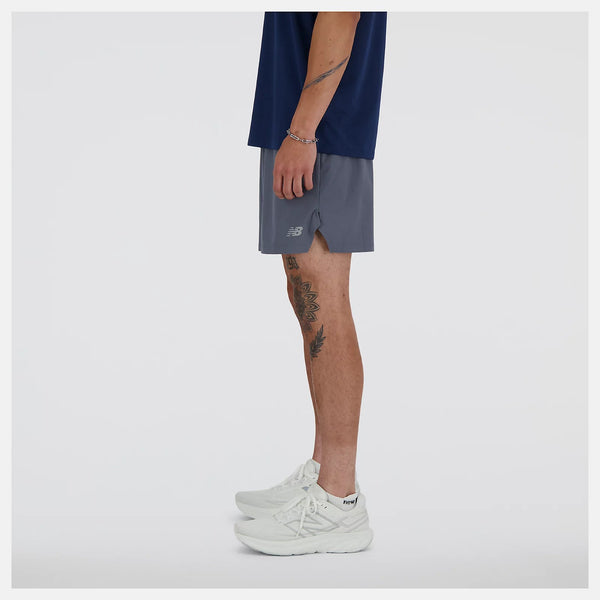 Person wearing gray athletic shorts with a visible brand logo on a white background