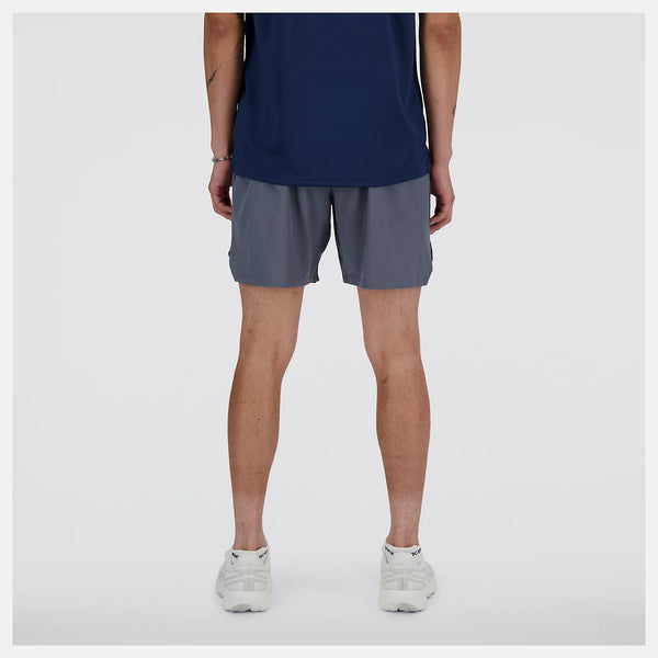 Person wearing gray shorts and a navy top on a white background