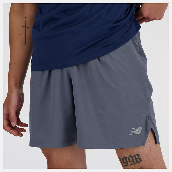 Person wearing gray athletic shorts with a brand logo on a white background