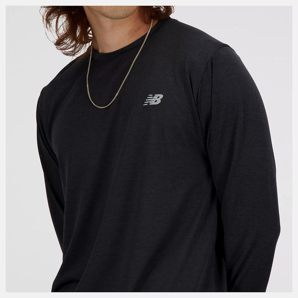 Person wearing a black long-sleeve shirt with a New Balance logo on a white background