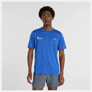Person wearing a blue athletic shirt with a logo on a gray background