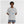 Person wearing a gray t-shirt with colorful graphic design on a white background