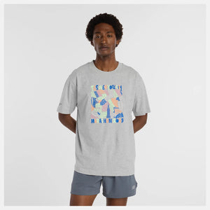 Person wearing a gray t-shirt with colorful graphic design on a white background