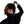 Person wearing a black turtleneck and wireless earbuds, with one hand adjusting hair against a white background