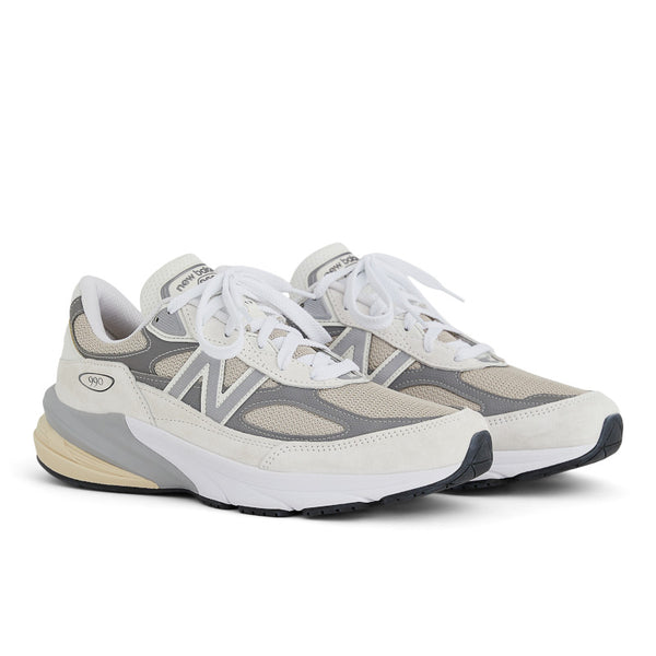 A pair of Unisex NB 990 V6 shoes with white laces and a white midsole.