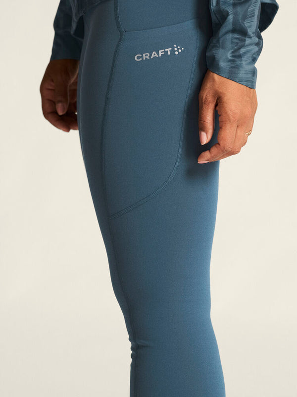 Blue athletic leggings with Craft logo on a beige background