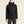 Person wearing a black jacket with a brand logo on a beige background