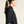 Woman wearing a black jacket with a visible brand logo on a beige background