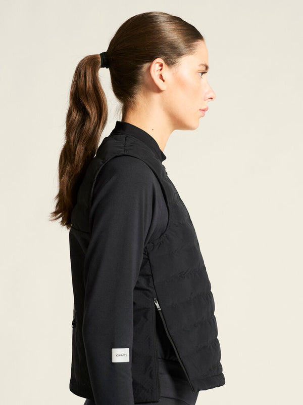 Woman wearing a black jacket with a visible brand logo on a beige background