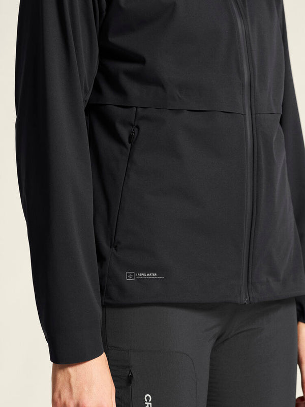 Black jacket with a visible brand logo on a beige background