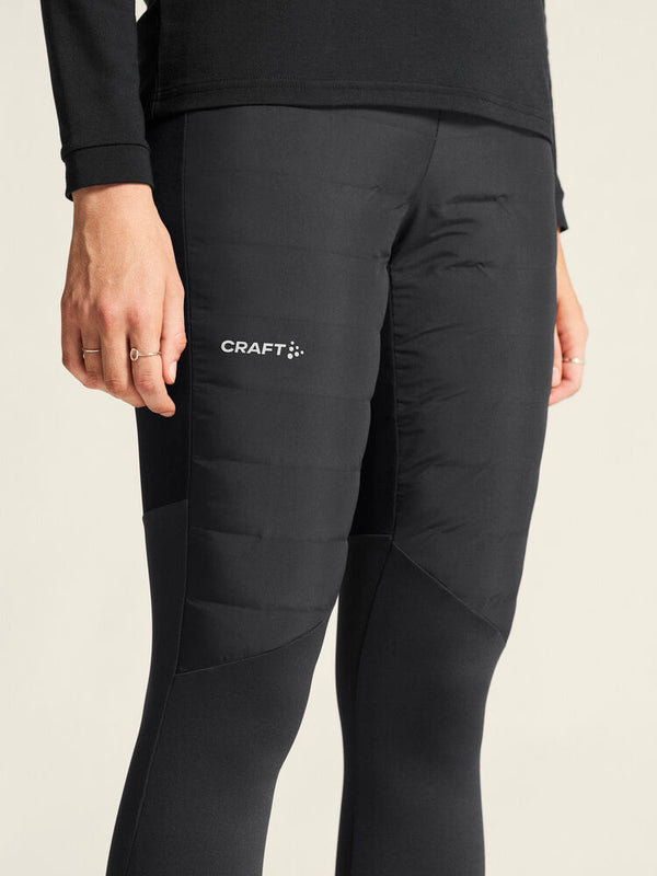 Black athletic pants with Craft logo on a beige background