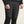 Person wearing black puffer pants with Craft logo on a beige background