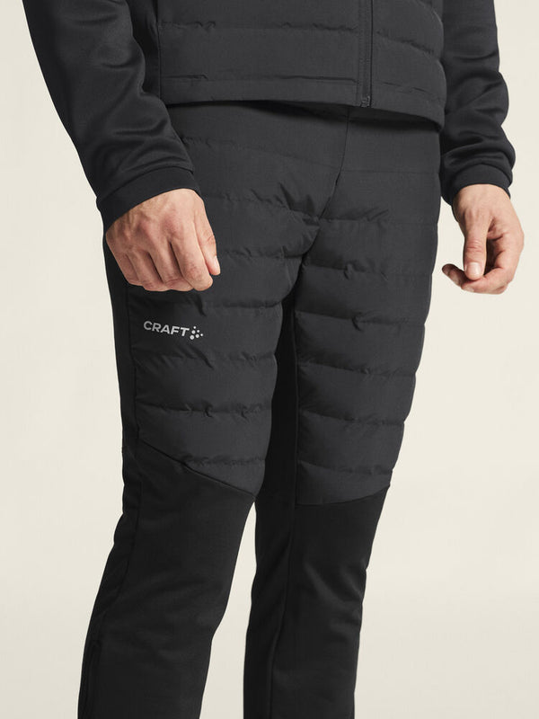 Person wearing black puffer pants with Craft logo on a beige background