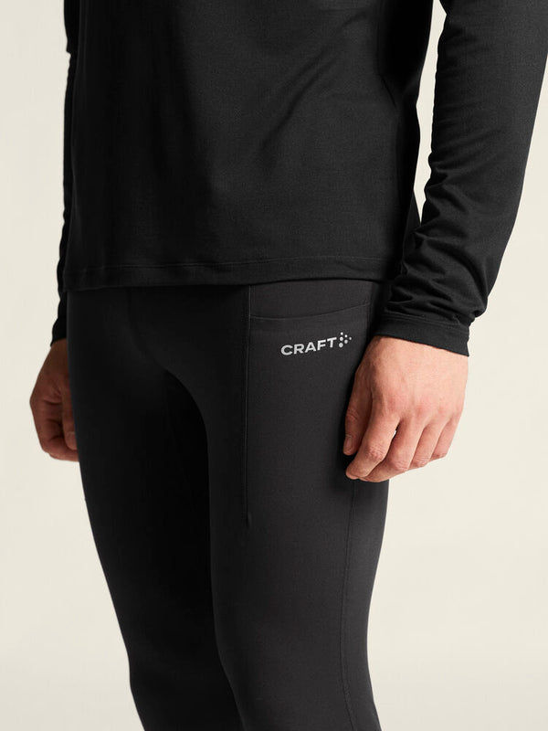 Person wearing black athletic leggings with Craft logo on a beige background