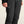 Black pants with a brand logo on a beige background