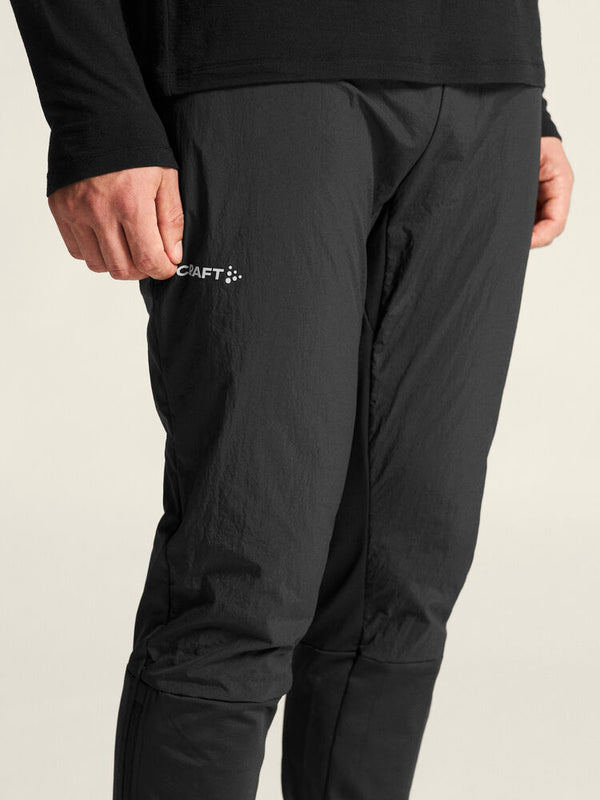 Black pants with a brand logo on a beige background