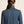 Person wearing a blue jacket with a neutral background