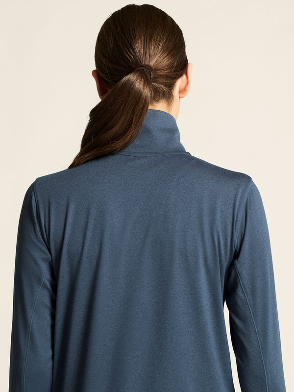 Person wearing a blue jacket with a neutral background