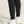 Black jogger pants with white sneakers on a neutral background