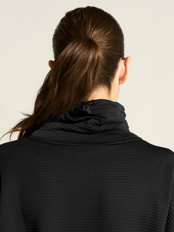Person wearing a black turtleneck with a neutral background