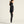 Woman wearing a black outfit on a light beige background