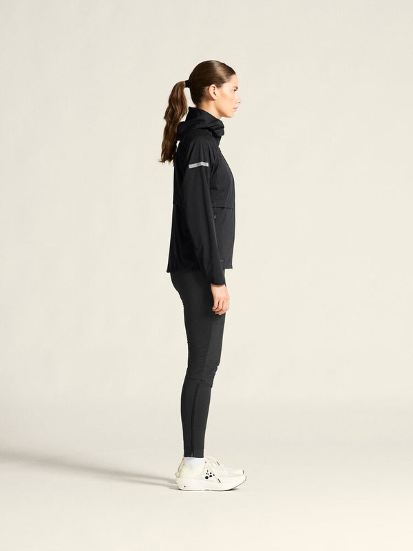 Woman wearing a black outfit on a light beige background