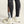 Black running leggings with a visible brand logo, paired with white running shoes on a neutral background.