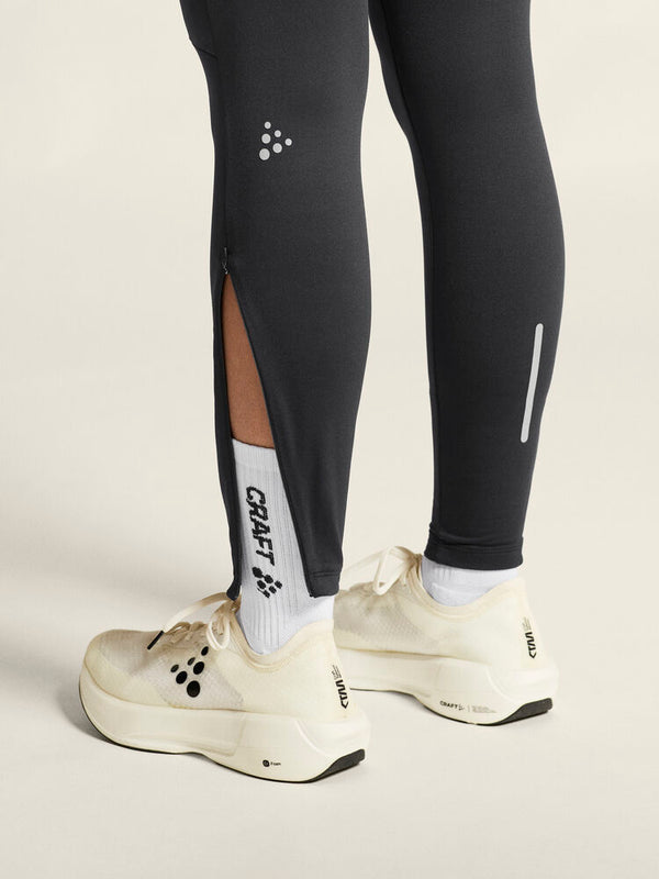 Black running leggings with a visible brand logo, paired with white running shoes on a neutral background.