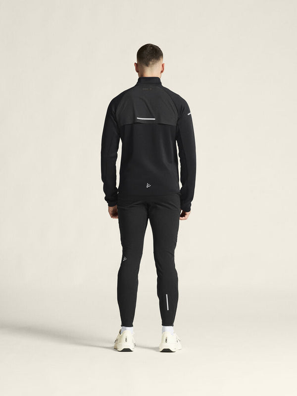 Person wearing a black athletic outfit on a light beige background