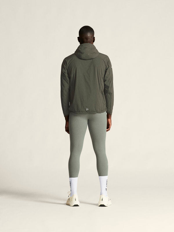 Person wearing a green jacket and leggings on a white background