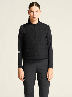 Person wearing a black pullover with a brand logo on a beige background