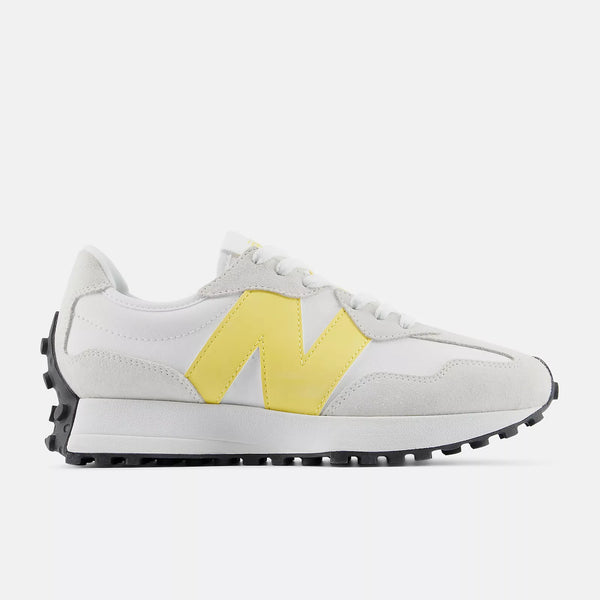 White sneaker with yellow accent and yellow New balance logo on a white background.