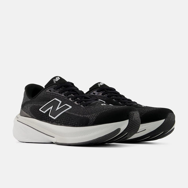 Black running shoes with white soles on a light gray background