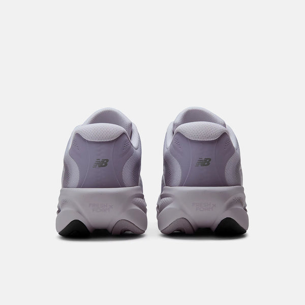 A pair of New Balance sneakers shown from the back, featuring a light lavender-purple and white design with a chunky sole and the signature 'NB' logo.