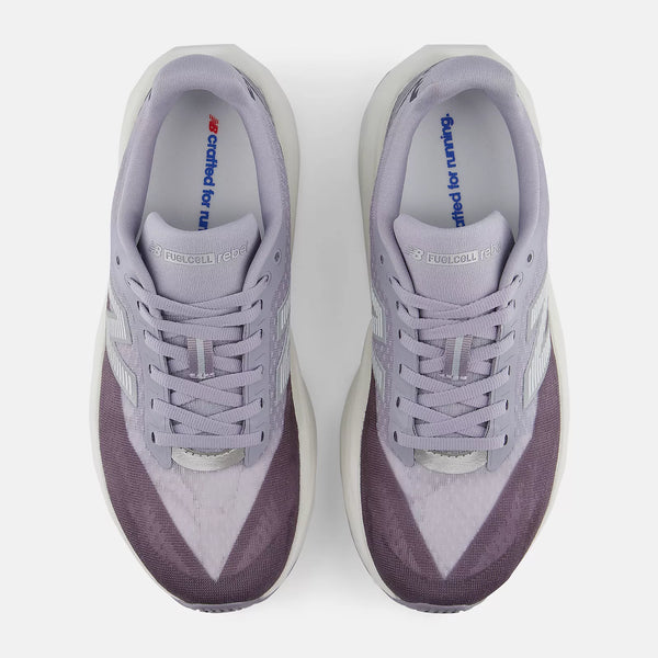 A pair of New Balance FuelCell Rebel v4 running shoes in a light lavender and dark purple colorway, shown from a top-down view on a light gray background.