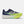 Navy and green running shoe with New Balance logo on a white background