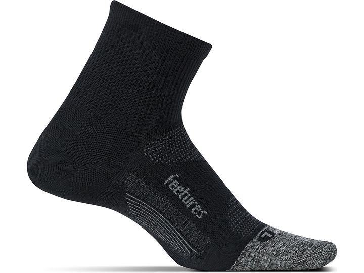 Medial view of the left foot wearing a Feetures Elite Ultra Light cushion quarter height sock in the color black