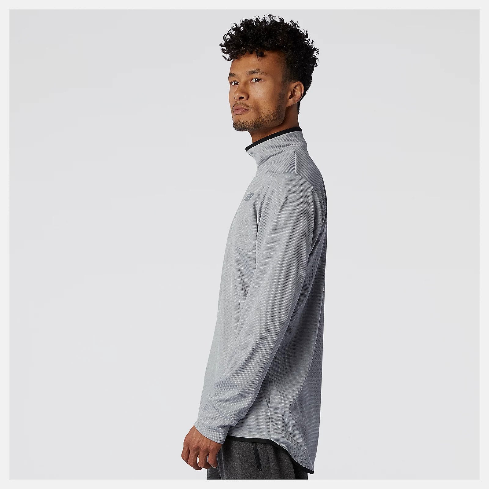 Side view of a model wearing the Men's Tenacity Quarter Zip by New Balance in the color Athletic Grey