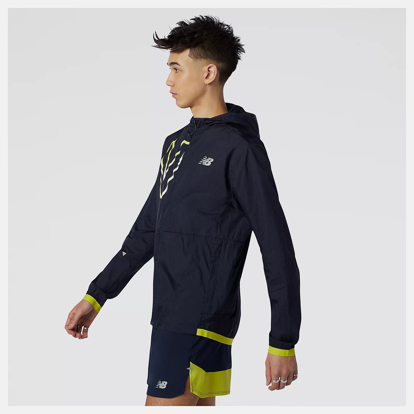 Side view of a model wearing the Men's Printed Impact Run Light Jacket from New Balance in Sulphur Yellow