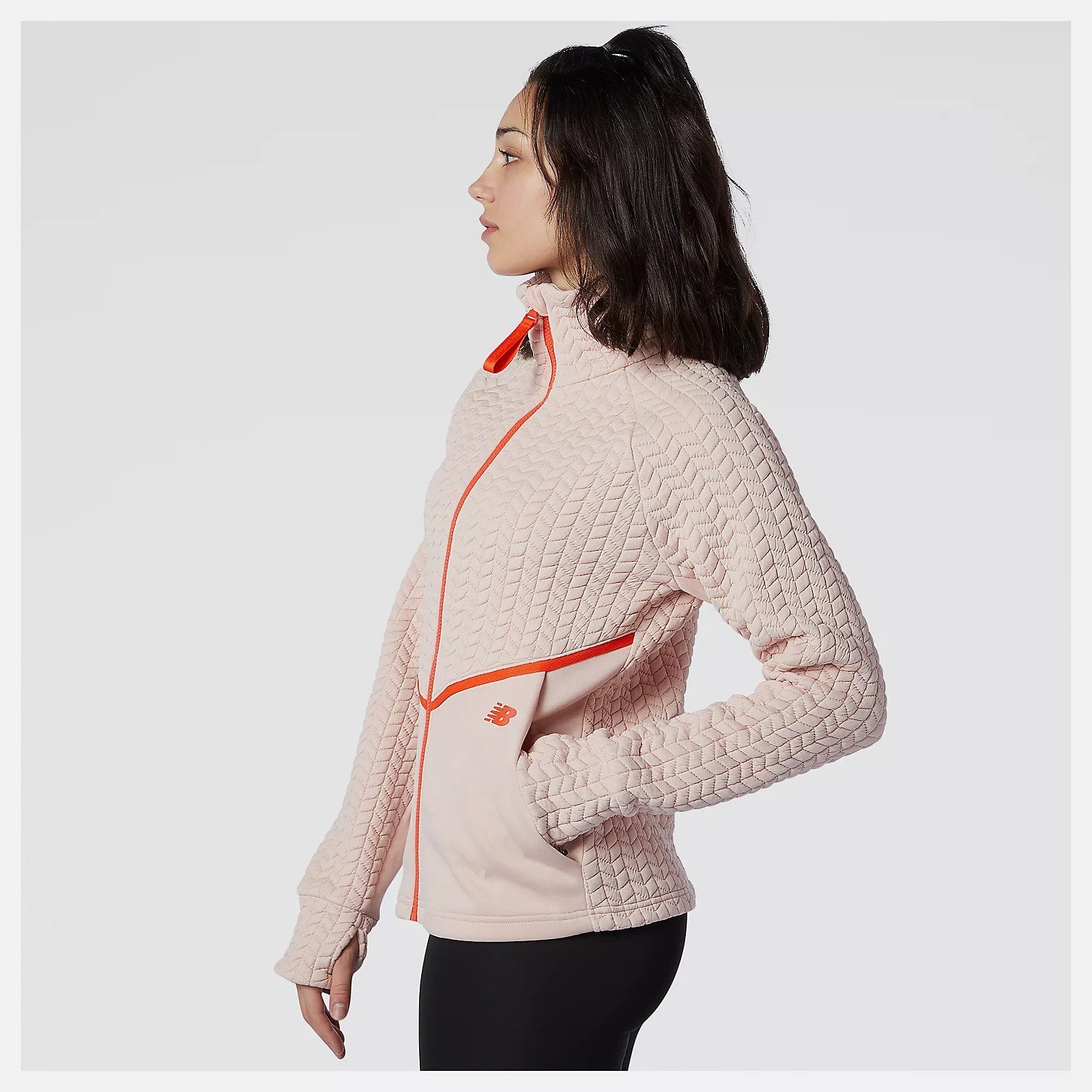 Side view of a model wearing the Women's Heatloft Athletic Jacket in the color Oyster Pink