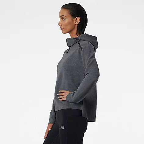 Side view of a model wearing the Women's Q Speed Shift Hoodie by New Balance in the color Black Heather