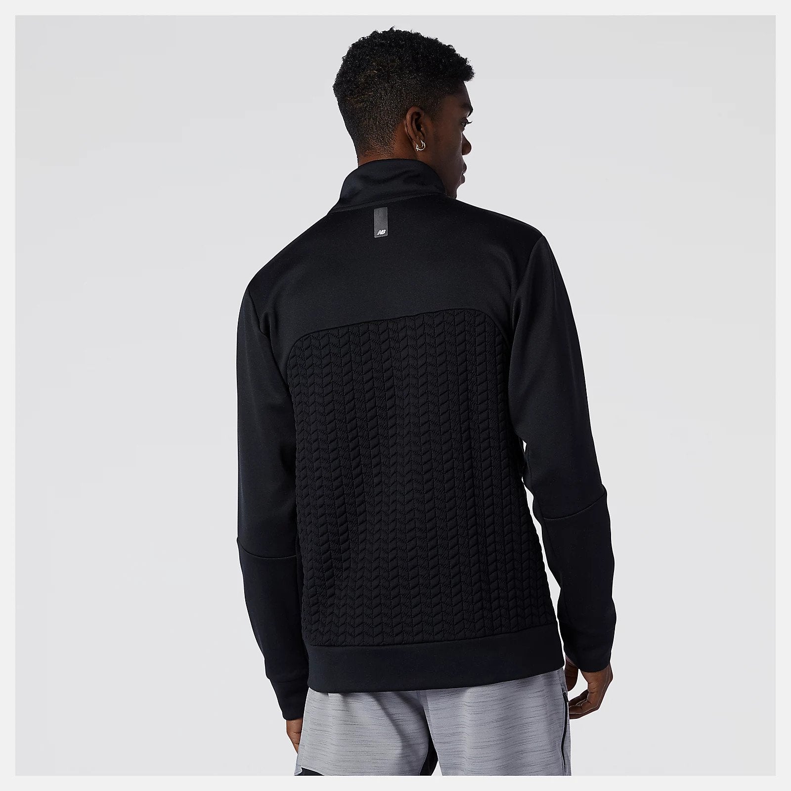 Back view of a model wearing the Men's Heat Loft Full Zip by New Balance in the color Alloy