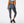 Back view of a model wearing the Women's Printed Accelerate Capri by New Balance in the color Black/Multi