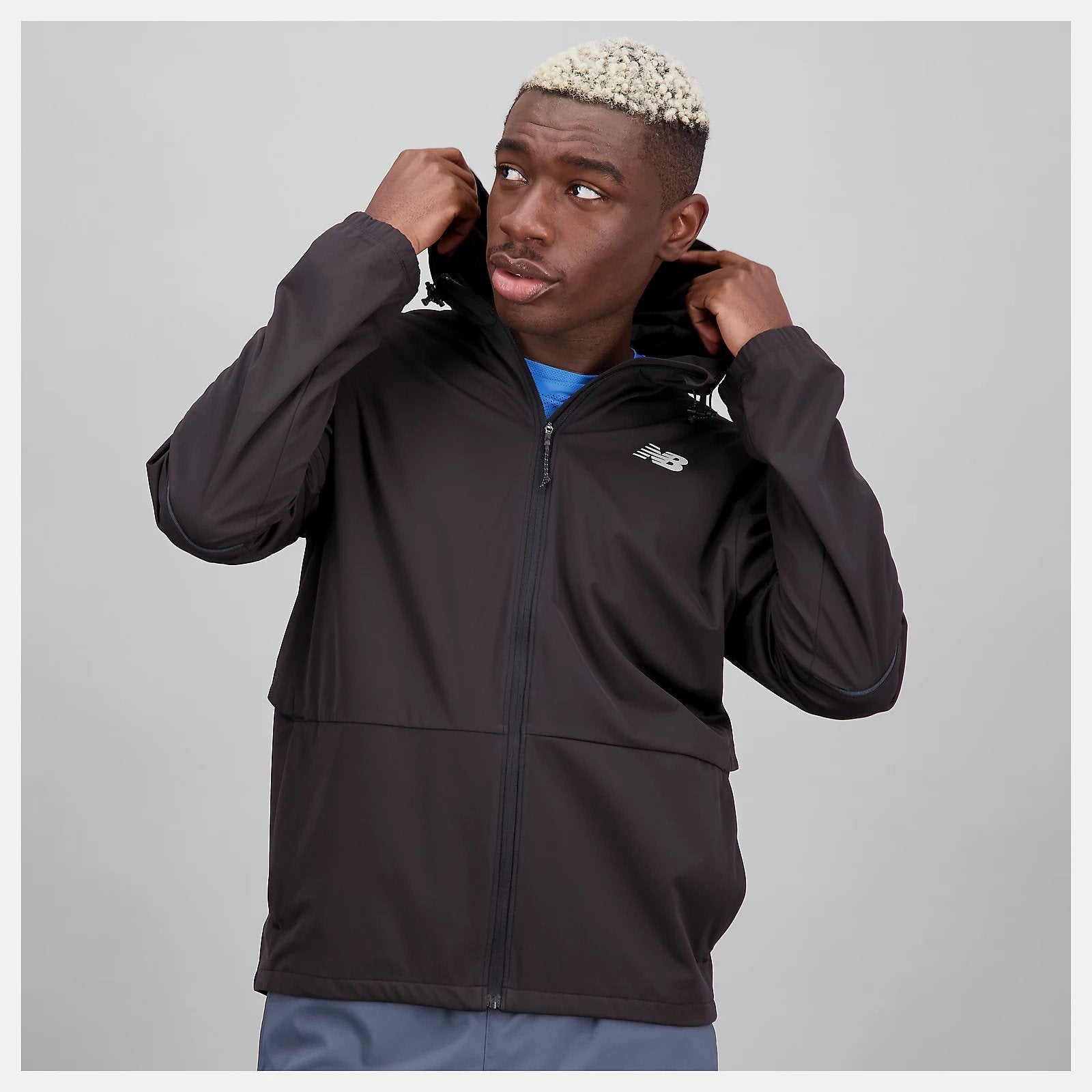 Front view of a model wearing the Men's Impact Run Water Defy Jacket by New Balance in Black